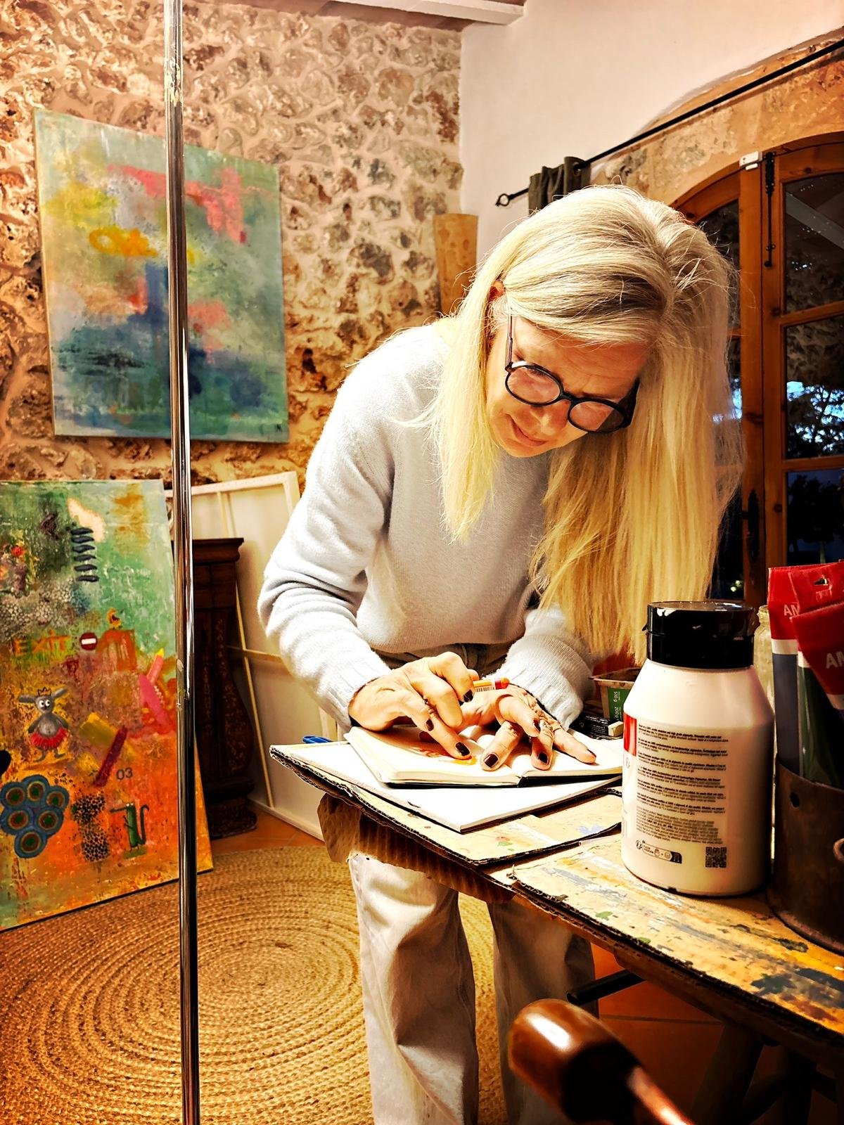 Crissi Honrath in ihrem Atelier auf Mallorca, bei der Arbeit an einer Skizze.
